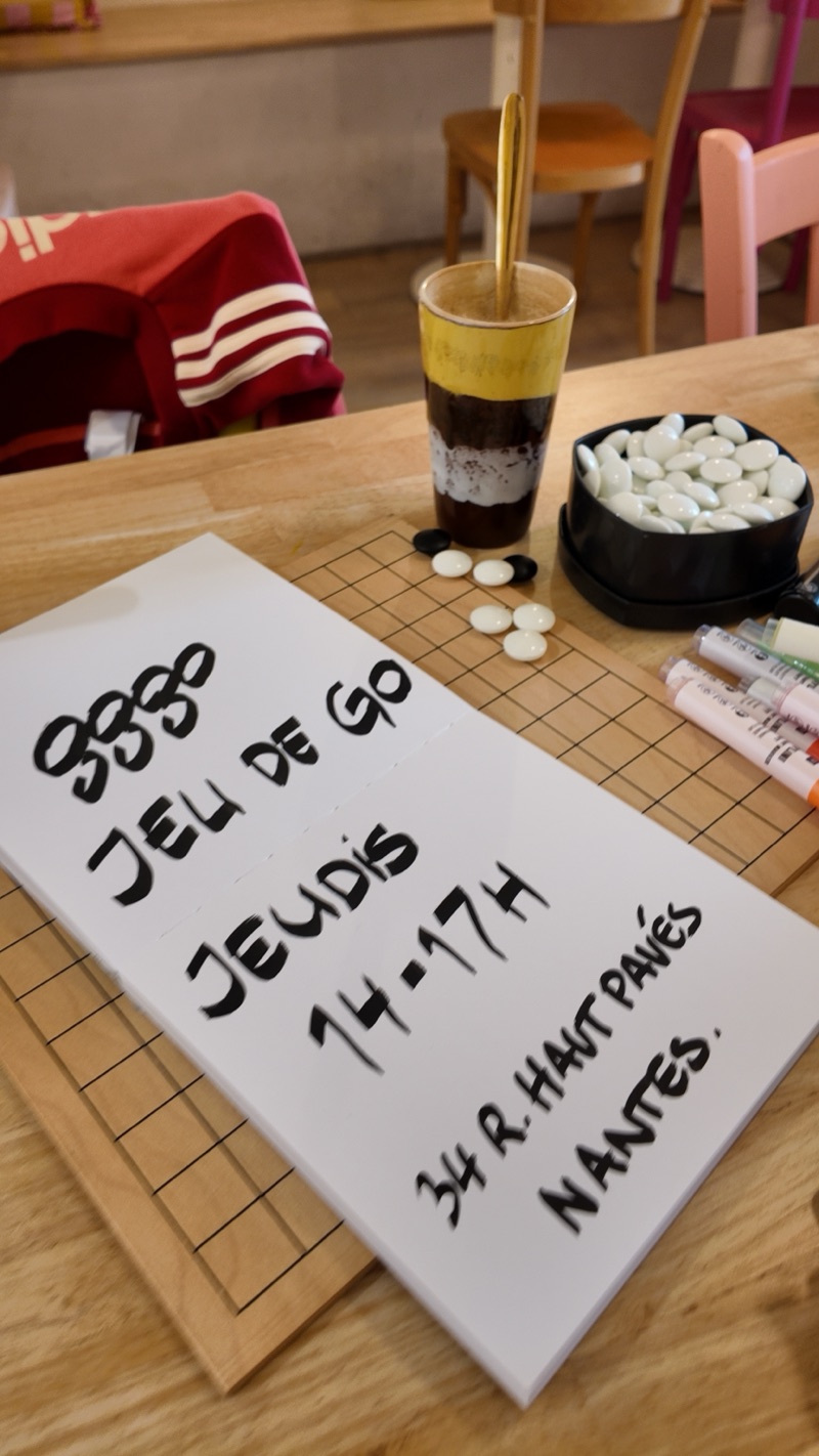 le panneau écrit au feutre à la main sur le goban : gggo, jeu de go, jeudis 14-17h, 34 r. Haut Pavés, Nantes, avec un café à côté